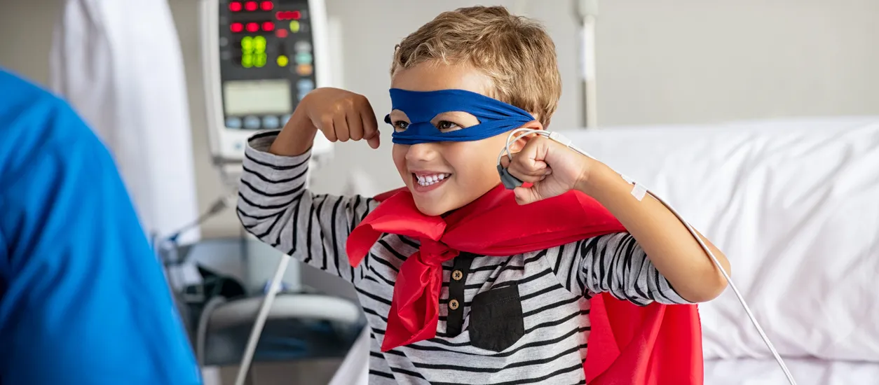 Young boy in hospital wearing a superhero style mask